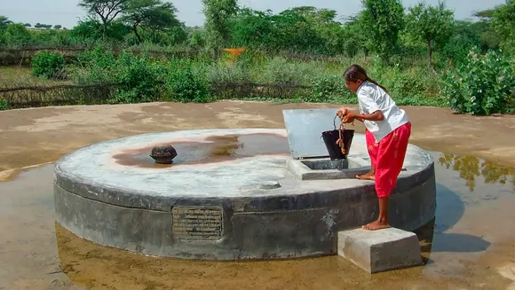 A young woman fills a bucket of water from a 'tanka', in Barmer district, Rajasthan