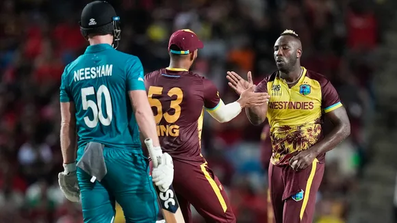West Indies' Andre Russell, right, gestures with teammate Brandon King as New Zealand's Jimmy Neesham, left, watches during the men's T20 World Cup cricket match between the West Indies and New Zealand at the Brian Lara Cricket Academy, Tarouba, Trinidad and Tobago, Wednesday, June 12, 2024.
