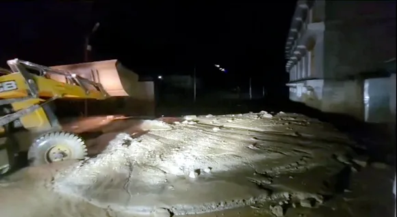 An earthmover being used to clear the mud accumulated following flash floods triggered by heavy monsoon rains, in Leh