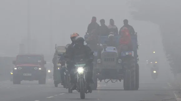 Tractor and bike on the road in a foggy morning