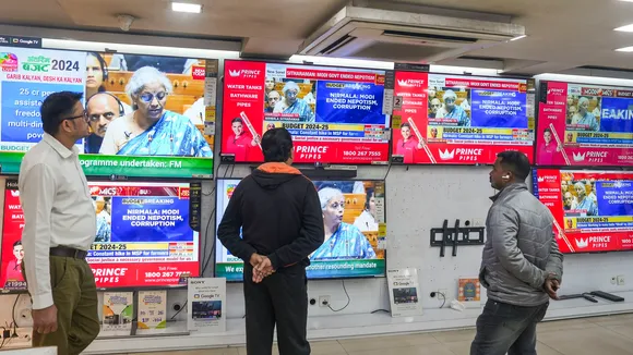 People watch Union Finance Minister Nirmala Sitharaman presenting the Interim Budget 2024 in Parliament, at a television showroom in Kolkata