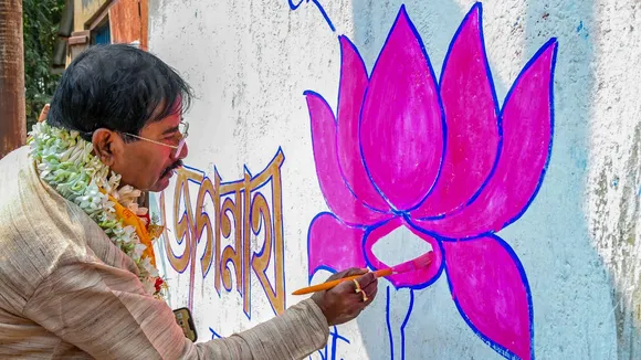 BJP candidate from Ranaghat Jagannath Sarkar paints the party's logo on a wall as part of the party's campaign ahead of Lok Sabha elections, in Nadia