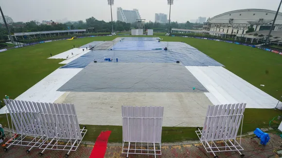 Groundsmen cover the Greater Noida Sports Complex ground during rains on the eve of the one-off Test cricket match between New Zealand and Afghanistan, in Greater Noida, Sunday, Sept. 8, 2024.