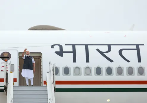 Prime Minister Narendra Modi waves while leaving for his visit to Paris, in New Delhi