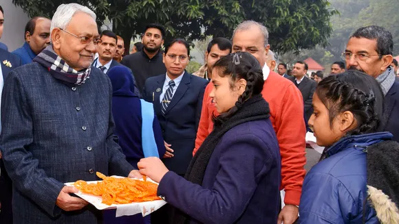 Nitish Kumar offers 'jalebi' to school students during the 75th Republic Day celebration, at his official residence in Patna, Friday, Jan. 26, 2024