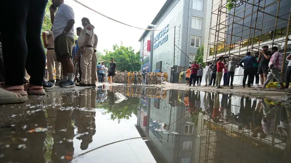 Security personnel stand guard near a UPSC exam coaching centre after three civil services aspirants died when the basement of the coaching centre was flooded by rainwater, in New Delhi, Sunday, July 28, 2024.