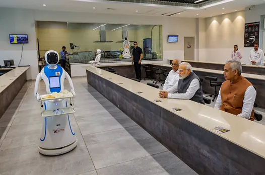 Prime Minister Narendra Modi being served tea by robots at Science City in Ahmedabad