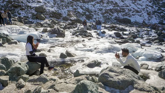 Tourists at a frozen stream, at Chandanwari in Anantnag district