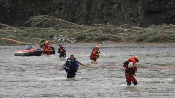 rescuers waling alongside a river in china