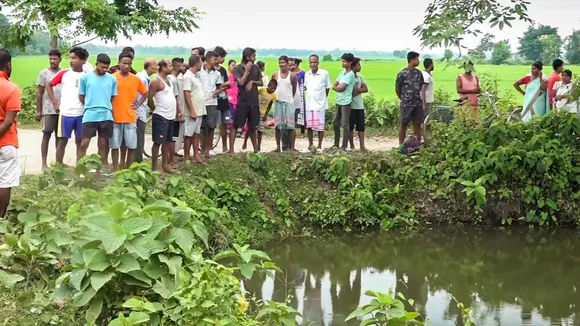 People gather near the pond where prime accused in the alleged rape of a minor girl jumped and died, at Dhing, in Nagaon district, Saturday, Aug. 24, 2024.