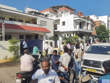 People outside the residence of Tamil Nadu Minister Senthil Balaji during a raid by Income Tax officials, in Karur