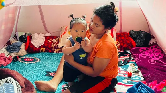 Kuki woman bringing up her newborn in a relief camp living away from her Meiti Husband