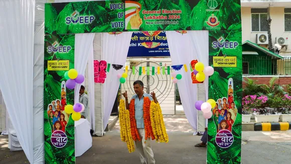 A worker decorates a polling booth on the eve of the sixth phase of Lok Sabha elections, in New Delhi, Friday, May 24, 2024