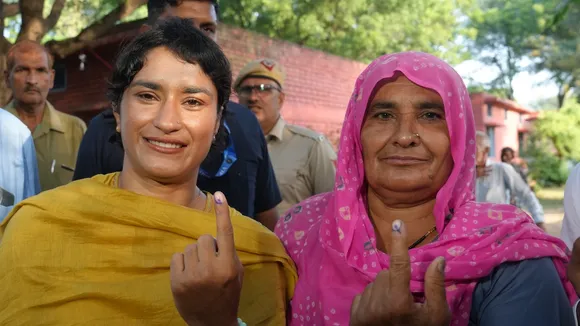 Congress candidate from Julana constituency Vinesh Phogat and her family member show their fingers marked with indelible ink after casting their votes at a polling station at Balali village during the Haryana Assembly elections, in Charkhi Dadri district, Saturday, Oct. 5, 2024.