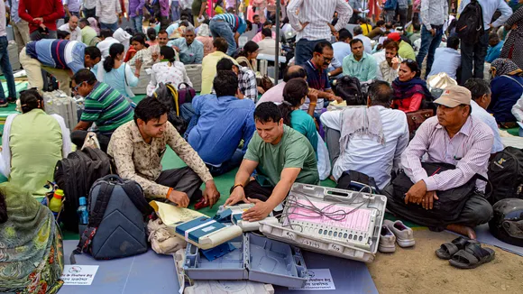 Polling officials collect EVMs and other election materal ahead of the second phase of UP Municipal elections at a distribution centre in Ghaziabad on May 10