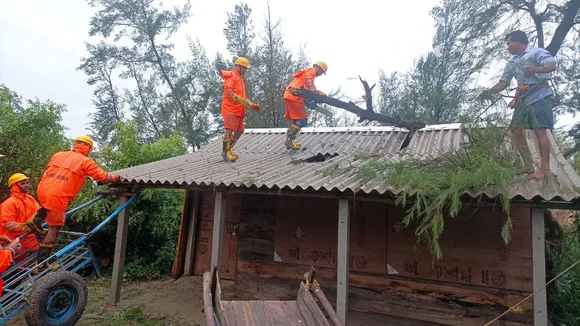 NDRF personnel remove an uprooted tree from the roof of a house after the landfall of Cyclone 'Remal', in South 24 Parganas district, Monday, May 27, 2024