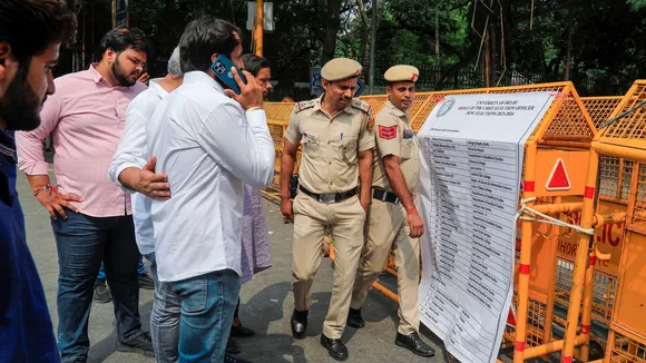 Police personnel stand guard outside a counting center on the counting day of the DUSU elections, in New Delhi