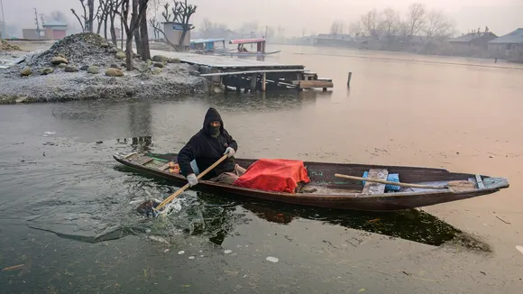A boatman rows through partially frozen Dal Lake, in Srinagar