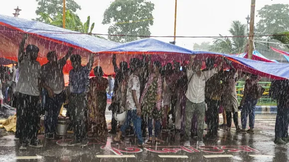 Agitators take cover during rains as junior doctors continue their 'cease work' and sit-in demonstration against the RG Kar Hospital incident, outside Swasthya Bhavan in Kolkata, Friday, Sept. 13, 2024