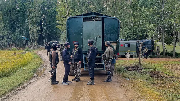 Security personnel stand guard after an encounter broke out between terrorists and security forces during cordon and search operation at Adigam village, in Kulgam district, Saturday, Sept. 28, 2024.