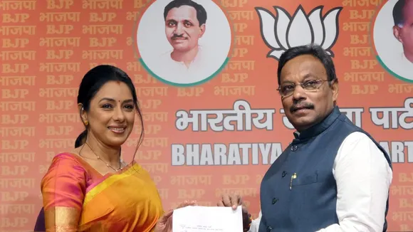 BJP General Secretary Vinod Tawde presents the party membership slip to television actress Rupali Ganguly as she joins the BJP, at the party headquarters, in New Delhi on Wednesday.