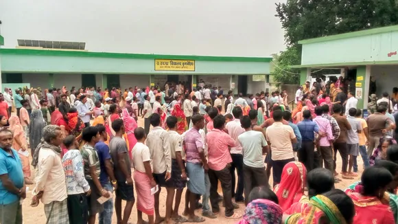 People wait a polling station to cast their votes in the seventh and last phase of Lok Sabha elections, in Jamtara district of Jharkhand, Saturday, June 1, 2024.