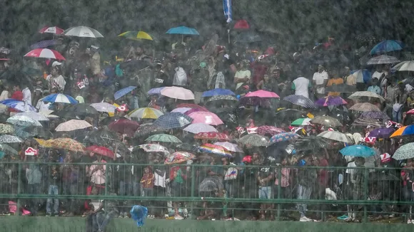 Spectators hold umbrellas as it rains during the second T20 International cricket match between India and Sri Lanka, at the Pallekele International Cricket Stadium, in Pallekele, Sunday, July 28, 2024.