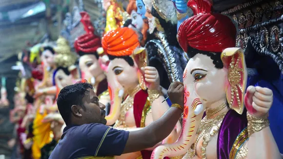 An artist gives final touches to the idols of Lord Ganesha ahead of the Ganesh Chaturthi festival