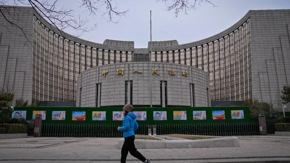 A woman jogs past China's central bank, or the People's Bank of China in Beijing