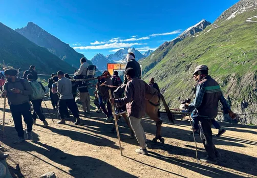 Porters carry a pilgrim at Brarimarg enroute to the holy Amarnath shrine, in Baltal, J & K, Thursday.jpg