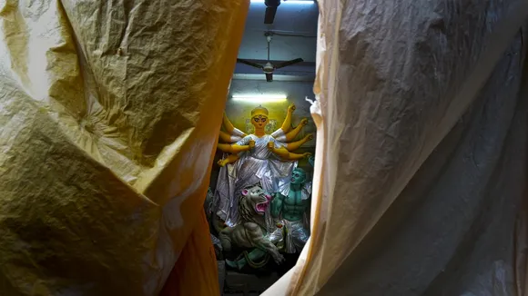 A clay idol of Goddess Durga placed under a shed for protection from rainwater on a rainy day, ahead of Durga Puja festival, at artisans’ village Kumartuli, in Kolkata, West Bengal