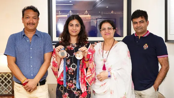 Paris Olympic bronze medalist shooter Manu Bhaker with her coach Jaspal Rana (L), mother Sumedha Bhaker (2R) and father Ram Kishan Bhaker (R) during visit to PTI office, in New Delhi, Friday, Aug. 16, 2024.