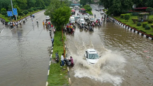 A vehicle moves through a flooded road after heavy downpour, in New Delhi, Friday, Aug. 23, 2024.