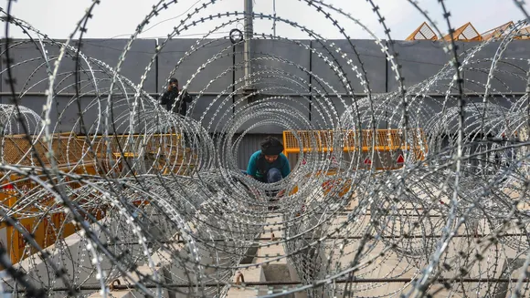 A worker lays down barbed wire on National Highway 44 in view of farmers' 'Delhi Chalo March', near Singhu border in Sonipat district