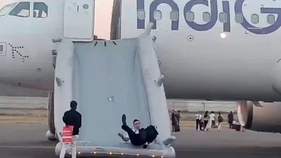 A pilot slides down from the Varanasi-bound IndiGo flight that received a bomb threat at the Indira Gandhi International Airport, in New Delhi, Tuesday, May 28, 2024