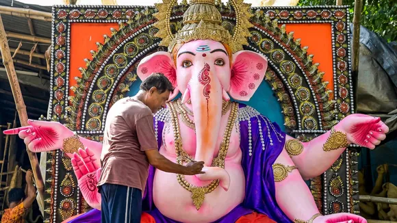 An artisan gives final touches to an idol of Lord Ganesh ahead of 'Ganesh Chaturthi' festival