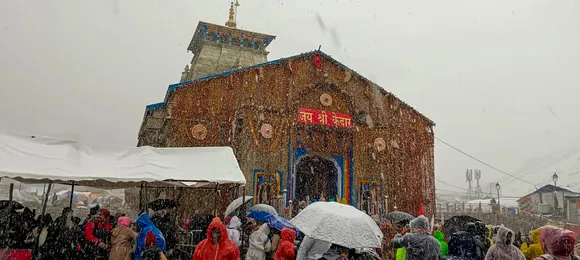 Devotees arrive to offer prayers at the Kedarnath Temple amid snowfall, in Rudraprayag district
