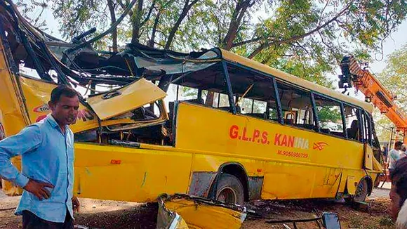 Locals near a damaged school bus after an accident near Mahendragarh, in Narnaul district, Haryana, Thursday, April 11, 2024
