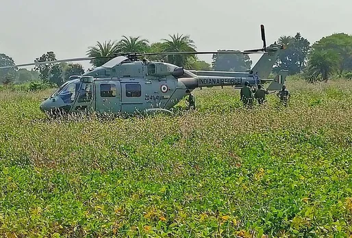 Locals gather near an Indian Air Force (IAF) chopper after an emergency landing in the fields at Dungariya, in Bhopal district