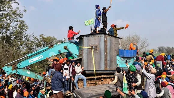 Farmers near an excavator modified to shield from police rubber bullets, during their protest over various demands, including a legal guarantee on the minimum support price (MSP) for crops and farm loan waiver, at the Punjab-Haryana Shambhu Border