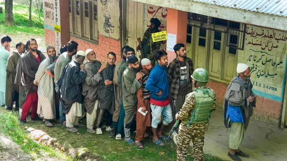 People wait in a queue to cast their votes at a polling booth during the sixth phase of Lok Sabha elections, at Noorbabad area in Kulgam district of South Kashmir, Saturday, May 25, 2024