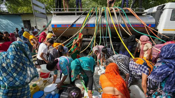People collect drinking water from a tanker amid ongoing Delhi water crisis, at Vivekanand camp in New Delhi, Thursday, June 13, 2024.