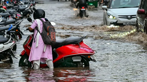 A commuter wades through a waterlogged road, amidst rains, in Thiruvananthapuram, Thursday, May 16, 2024