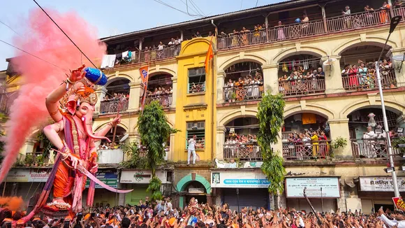 People watch devotees celebrate in a ‘Ganesh Visarjan’ procession for immersion of the idol of Lord Ganesha during 'Ganesh Chaturthi' festivities, in Mumbai