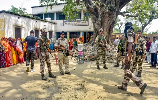 Security personnel stand guard at a polling booth during Panchayat repolls, in Murshidabad district