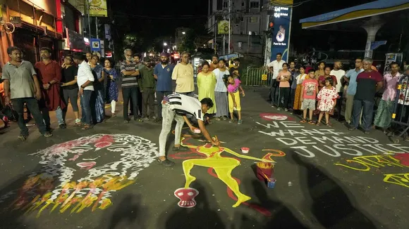 An artist makes a graffiti on a road during a protest over the alleged sexual assault and murder of a trainee doctor, in Kolkata, Sunday, Sept. 8, 2024.