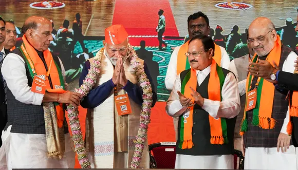 Narendra Modi being garlanded by Rajnath Singh during the BJP National Council meeting at the Bharat Mandapam, in New Delhi, Saturday, Feb. 17, 2024. Amit Shah and JP Nadda are also seen.