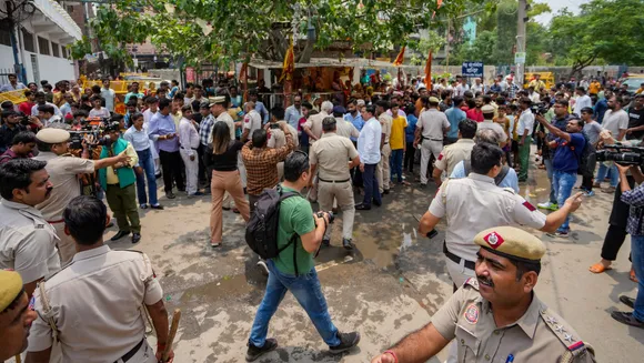Police personnel attempt to pacify locals protesting against the removal of a portion of a temple in Mandawali area of New Delhi