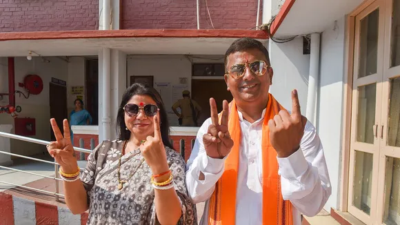 Bharatiya Janata Party (BJP) candidate from Allahabad constituency Neeraj Tripathi and wife Kavita Tripathi shows their fingers marked with indelible ink after casting vote