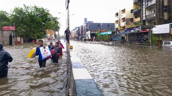 People wade through a waterlogged road during heavy rain owing to Cyclone Michaung, in Chennai, Monday, Dec. 4, 2023.